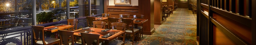 Several wood tables and chairs in a large dining room with wood accents