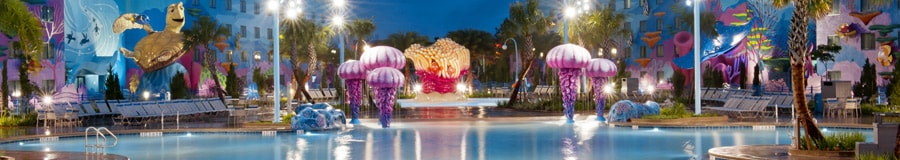 Une vue nocturne de la piscine Finding Nemo au Disney’s Art of Animation Resort avec des aires de jeux colorées