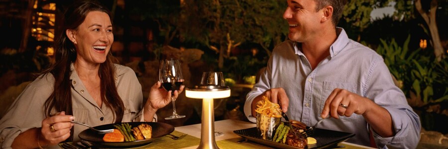 Two Guests enjoying dinner together at ‘AMA‘AMA in Aulani, A Disney Resort & Spa