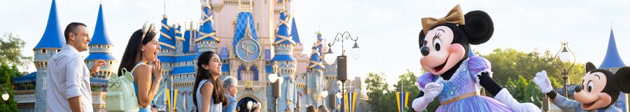 Mickey Mouse y Minnie Mouse saludan a una emocionada familia cerca del castillo Cinderella Castle en el Parque Temático Magic Kingdom