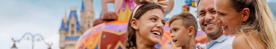 A family of 4 watching a parade in Magic Kingdom park