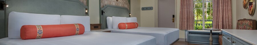 Una habitación de hotel de Disney’s Port Orleans Resort con una cómoda, sofá para dos personas, ventilador de techo y 2 camas