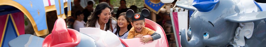 Mom and kids riding Dumbo in Disneyland