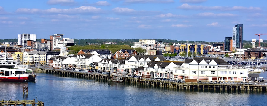 The Southampton port in England with waterfront buildings, docked boats and a pier The Southampton port in England with waterfront buildings, docked boats and a pier