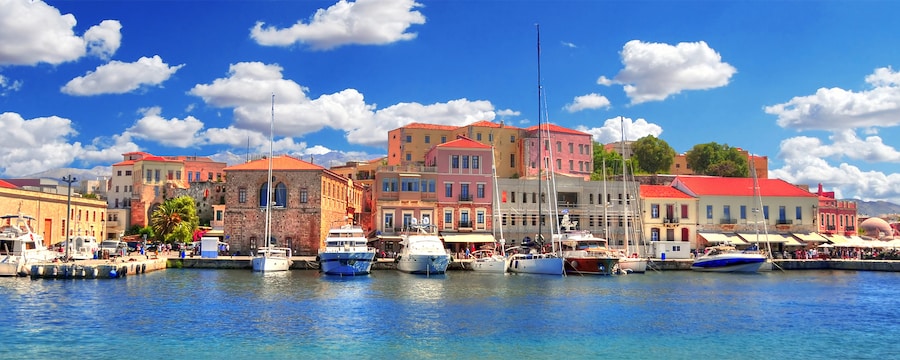 The harbor at Chania, Greece with boats in the water and restaurant on land The harbor at Chania, Greece with boats in the water and restaurant on land