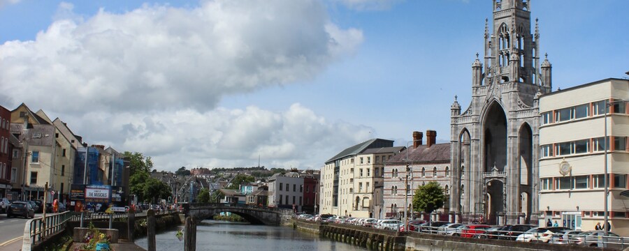 The Gothic Revival façade of Holy Trinity Church and other historic buildings line the River Lee in Cork, North Ireland