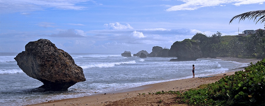 Large stones with pointed bases eroded by surf sit along a beach in a tropical cove Large stones with pointed bases eroded by surf sit along a beach in a tropical cove