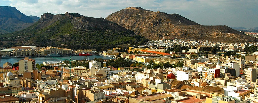 Una ciudad cerca de una cadena montañosa Una ciudad cerca de una cadena montañosa