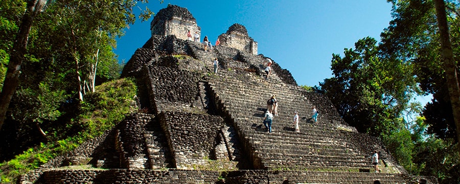 People climb the steep stairs of an ancient Mayan ruin at Costa Maya Mexico People climb the steep stairs of an ancient Mayan ruin at Costa Maya Mexico