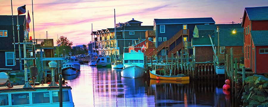 Fishing boats next to docks in a canal lined by houses