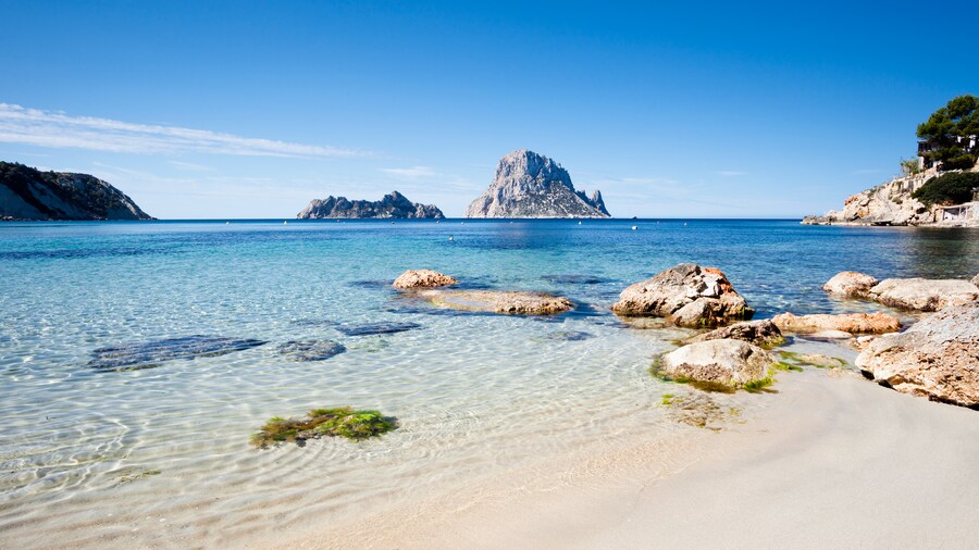 Mediterranean waves wash up along the coast of Ibiza, with rock formations in the horizon