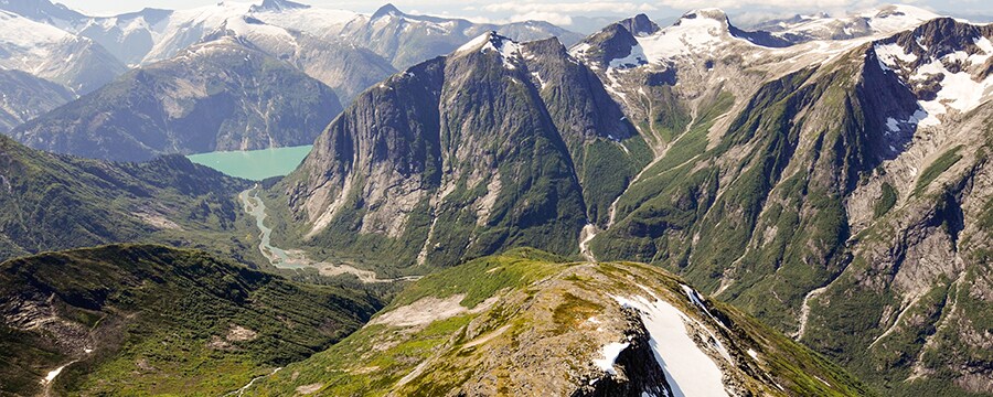 Aerial shot of snow capped mountains with steep cliff faces and the valleys between them