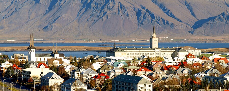 Town with buildings and large mountain in the backgroundand a body of water between them