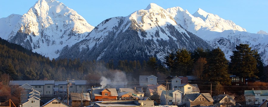 A town near a forest and a mountain range A town near a forest and a mountain range