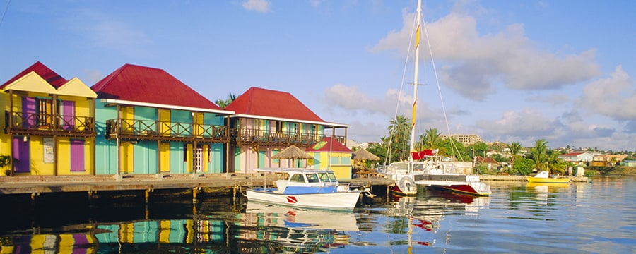 Two boats docked in front of low rise buildings in Antigua Two boats docked in front of low rise buildings in Antigua