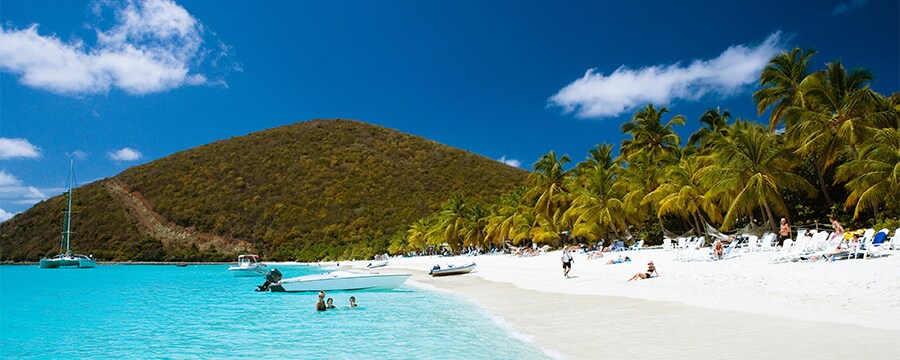 Botes, nadadores y personas tomando el sol en una playa de St. Maarten