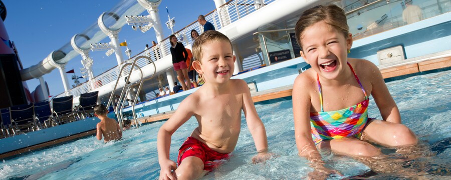 Smiling children in a shallow pool located on a ship deck
