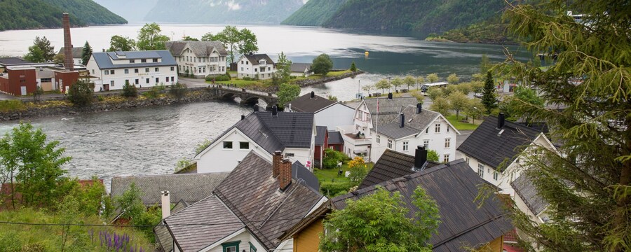 Un pueblo noruego lleno de casas a lo largo de la costa, cerca de un puente de piedra
