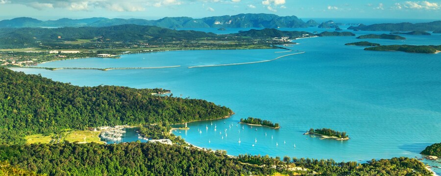 A small marina with sailboats amid forested hills on Langkawi Island, Malaysia
