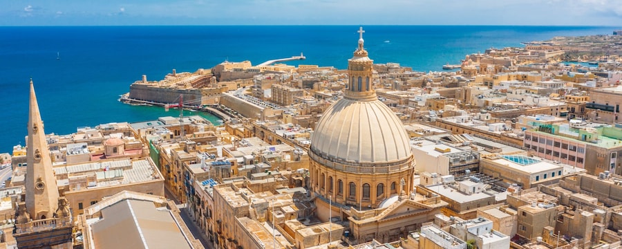 The walled city of Valletta in Malta featuring buildings and temples along the Mediterranean Sea The walled city of Valletta in Malta featuring buildings and temples along the Mediterranean Sea