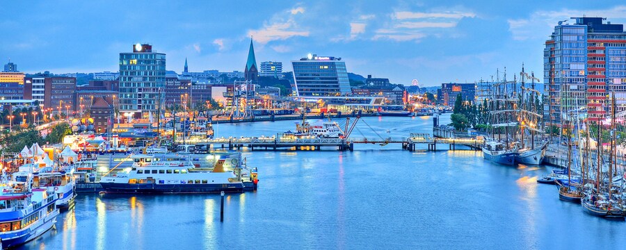 El puerto de Kiel con veleros de madera, yates y otros buques marítimos rodeados de rascacielos y edificios de la ciudad
