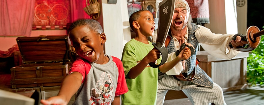 A pirate teaches 2 young Guests how to snarl and sword fight