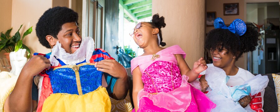 Family of 3 with Disney princess costumes in hand