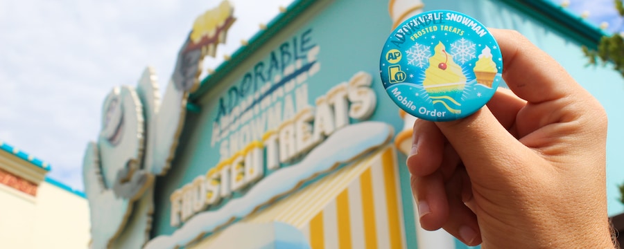 AP Button held in front of the exterior of Adorable Snowman Frosted Treats