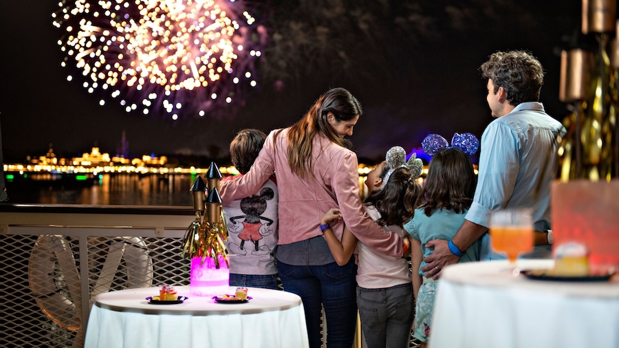 A man, woman and their children watching fireworks at a fireworks dessert party