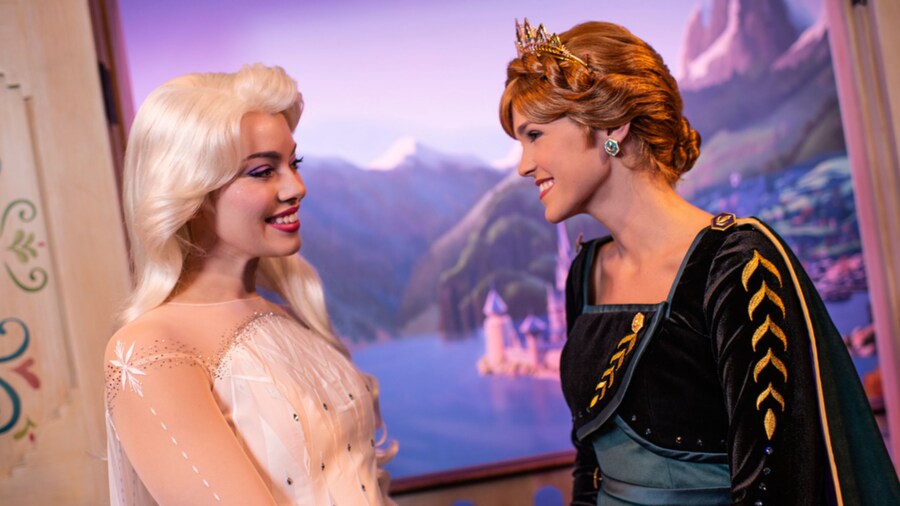 Anna and Elsa smile at each other at Royal Sommerhus in EPCOT