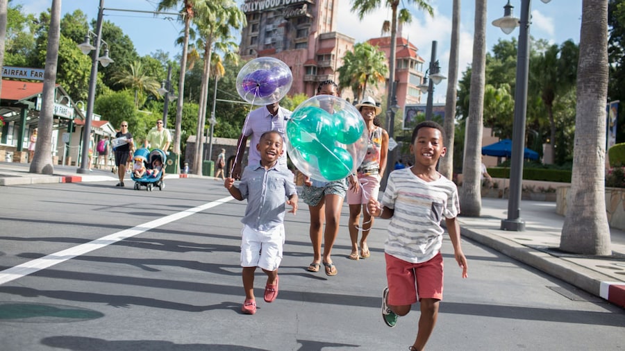 Jóvenes visitantes con globos de Mickey en Sunset Boulevard