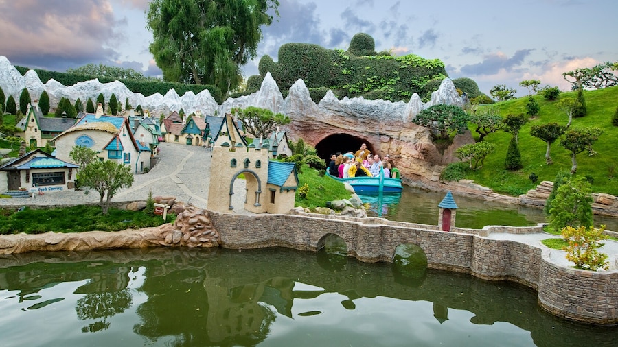 A Storybook Land Canal Boat full of Guests drifts gently past miniature villages