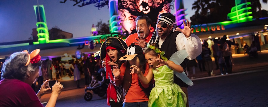 Grandma snaps pics of grandpa, dad and 3 kids in Halloween costumes near the Disney California Adventure Park entrance with Oogie Boogie and bats overhead