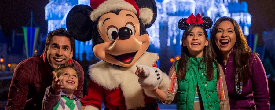 一群家人与装扮成圣诞老人（Santa Claus）的米奇老鼠（Mickey Mouse）在有着浓浓节日气息的灰姑娘城堡（Cinderella Castle）前一起摆姿势