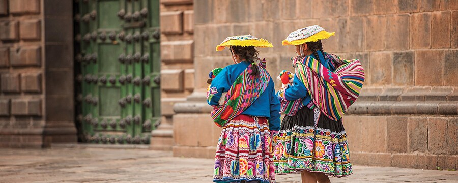 Women in traditional dress stroll through Cusco.  