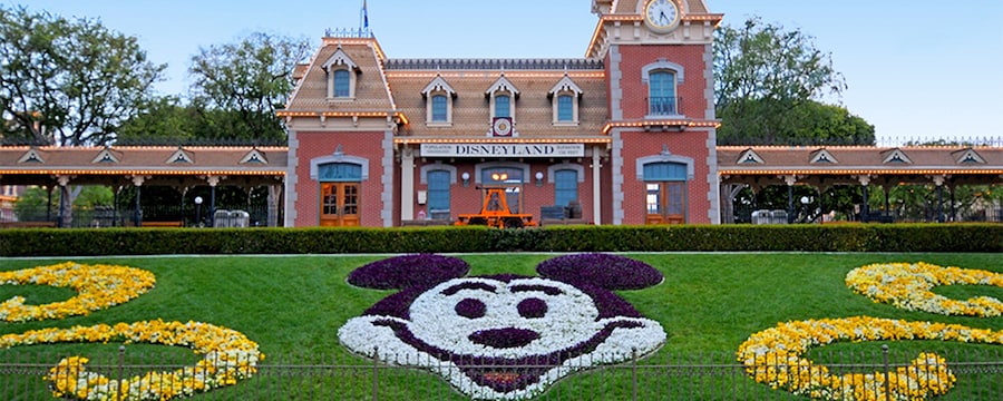 The Main Entrance to Disneyland Park with the train station and floral Mickey display