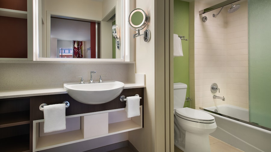 Standard Room with 2 double size beds, dresser, TV, artwork of animated Disney Characters and a bathroom