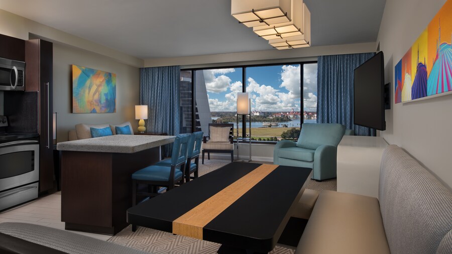 A booth and a table near a bar, a microwave, an oven and a living area with a couch, a window and a TV