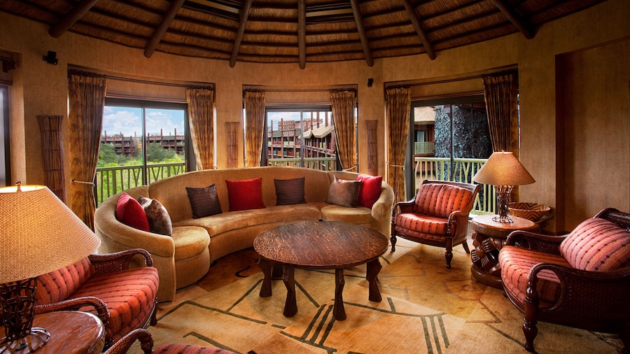 Turreted living area with sliding-glass balcony doors, sofa, coffee table and 3 easy chairs