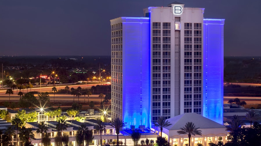 Hotel con luces encendidas de noche y palmeras