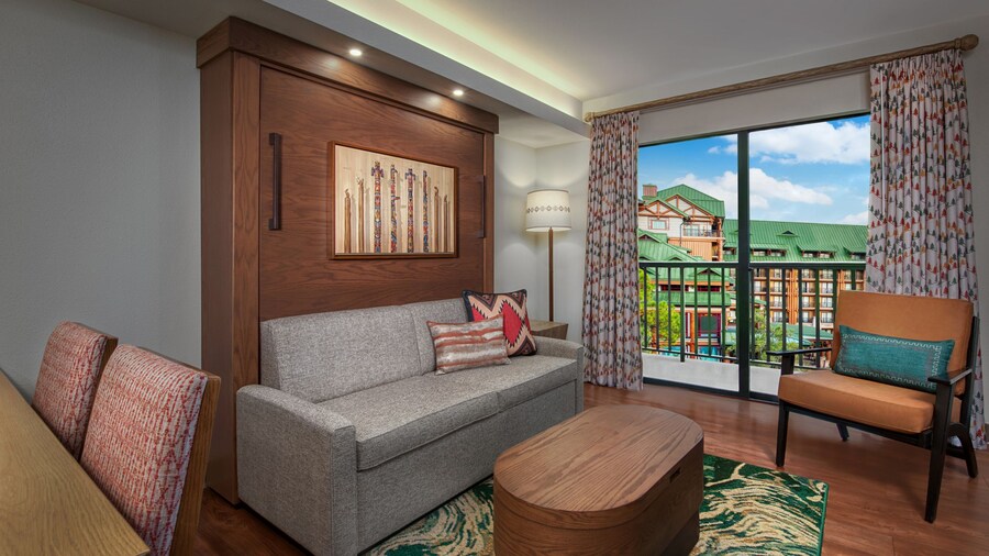 A sitting area with a couch, chair and coffee table overlooking a patio