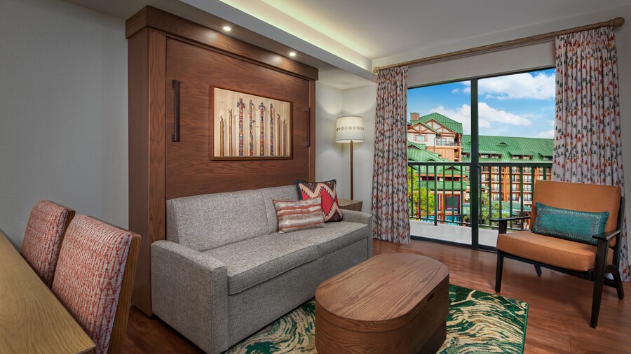 A seating area in a hotel room overlooking a courtyard 