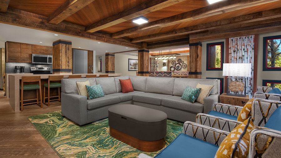 A large seating area flanked by kitchen and dining areas in a hotel suite
