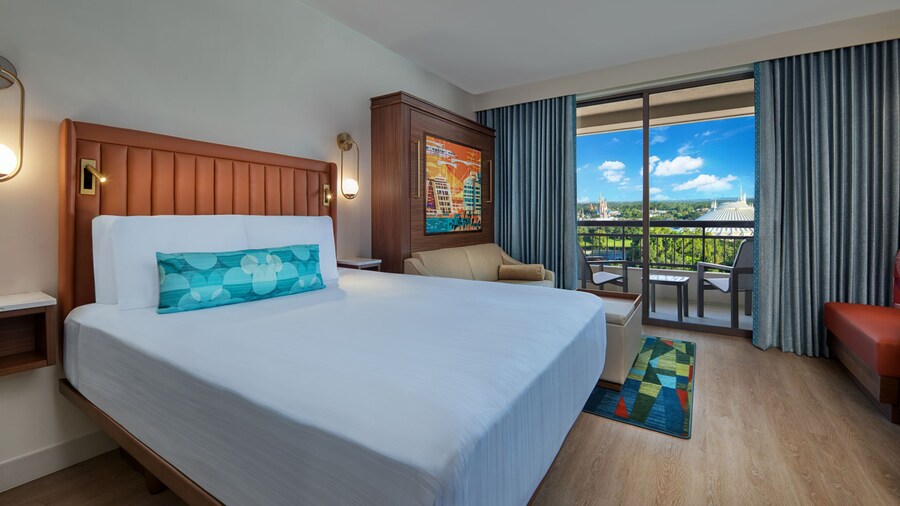 A Bay Lake Tower at Disney's Contemporary Resort Deluxe Studio Theme Park View room with a bed, a sofa, a low table and a balcony with views of Magic Kingdom park
