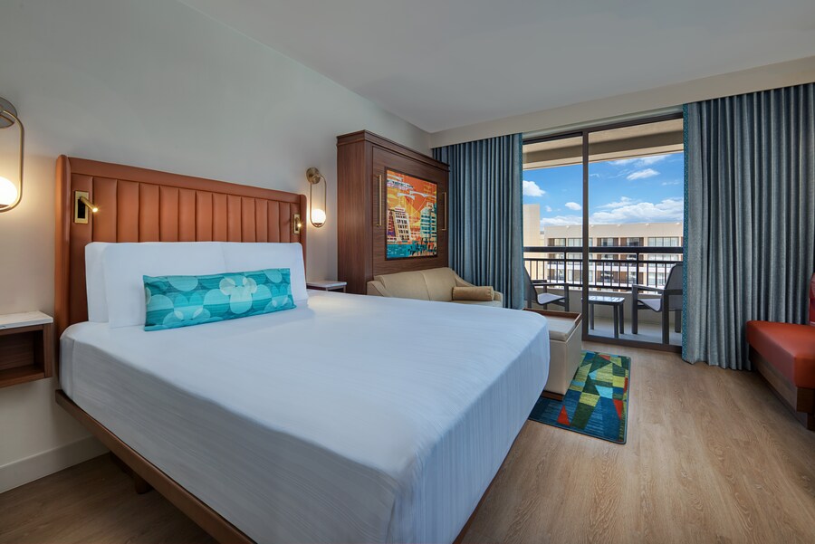 A Bay Lake Tower at Disney's Contemporary Resort Deluxe Studio Preferred View room with a bed, a sofa and balcony with views of Bay Lake