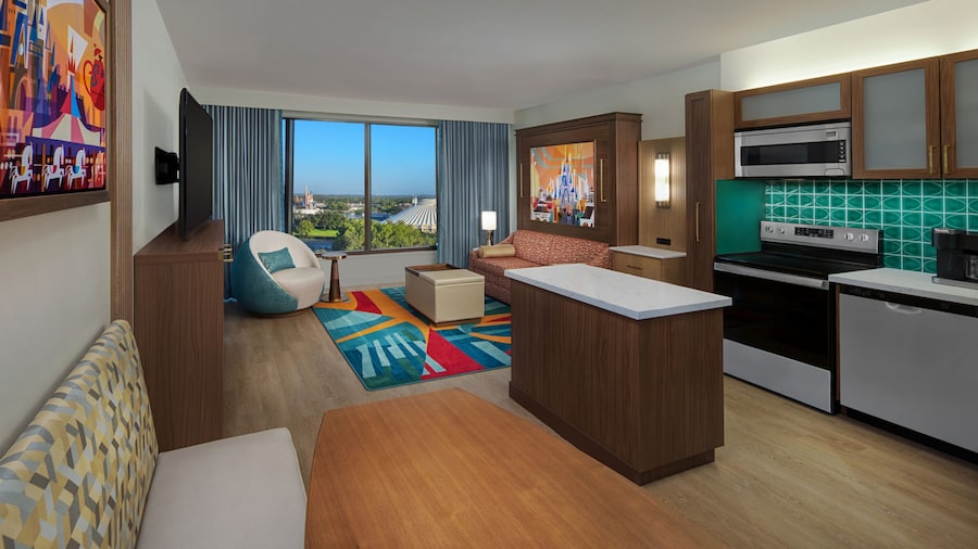 A Villa with a kitchen, dining area and a living area with a sofa, coffee table, chair and TV at Bay Lake Tower at Disney’s Contemporary Resort