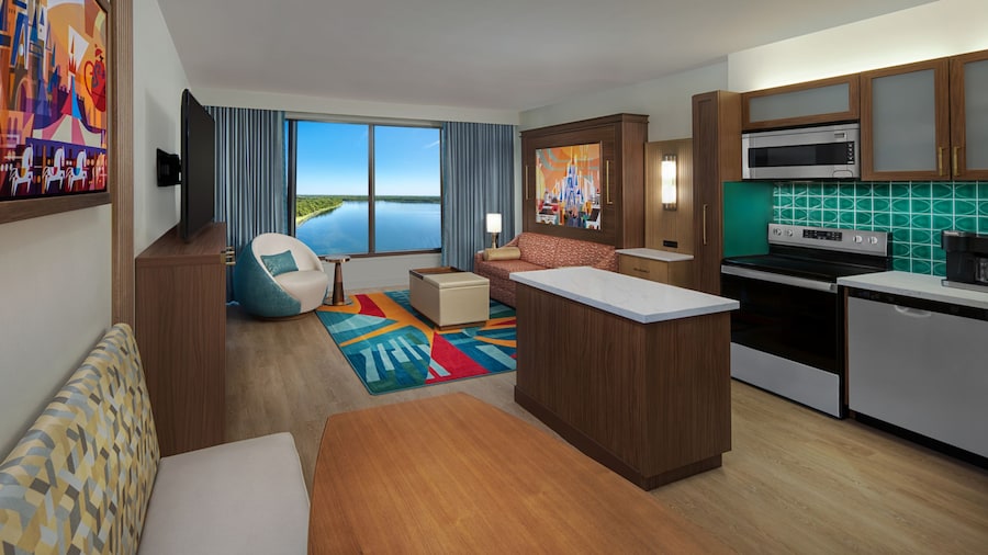 A Villa with a kitchen, dining area and a living area with a sofa, coffee table, chair and TV at Bay Lake Tower at Disney’s Contemporary Resort