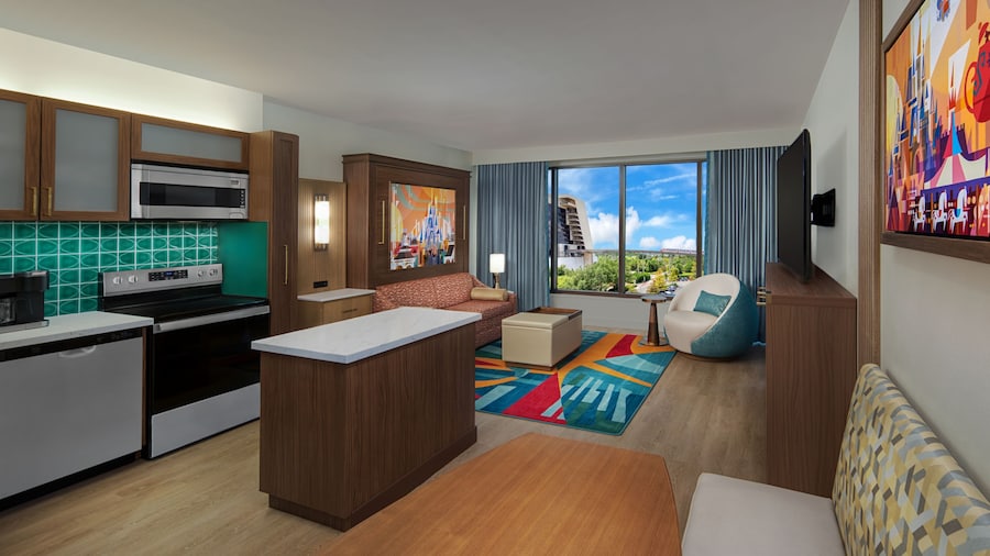 A Villa with a kitchen, dining area and a living area with a sofa, coffee table, chair and TV at Bay Lake Tower at Disney’s Contemporary Resort