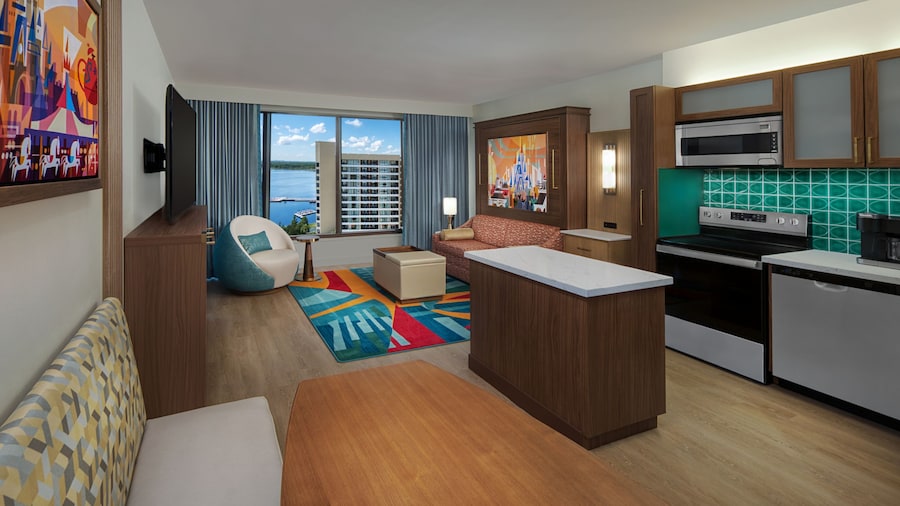 A Villa with a kitchen, dining area and a living area with a sofa, coffee table, chair and TV at Bay Lake Tower at Disney’s Contemporary Resort