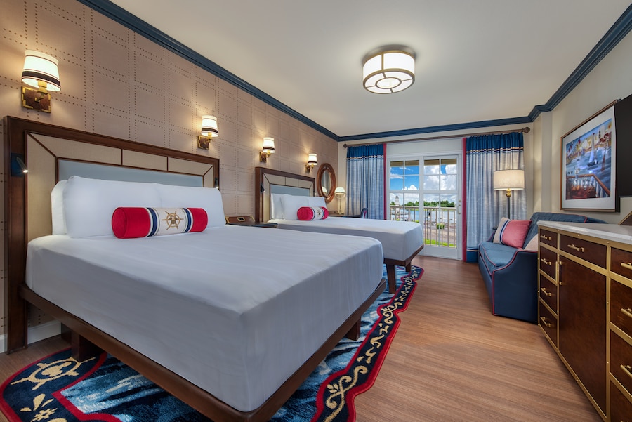 A Disney’s Yacht Club Water View Club Level Room with 2 beds, a sofa, a dresser and a deck